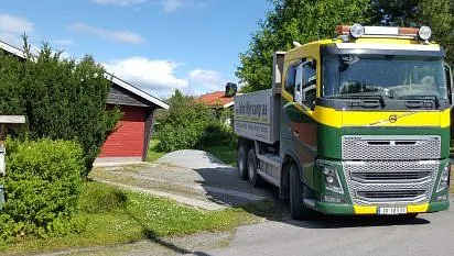 Lastebil i innkjørsel til hus